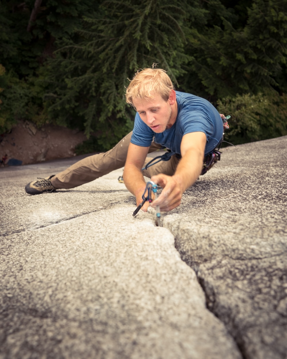 An increasingly dated photo of Jeremy placing a cam while climbing a finger crack in Squamish